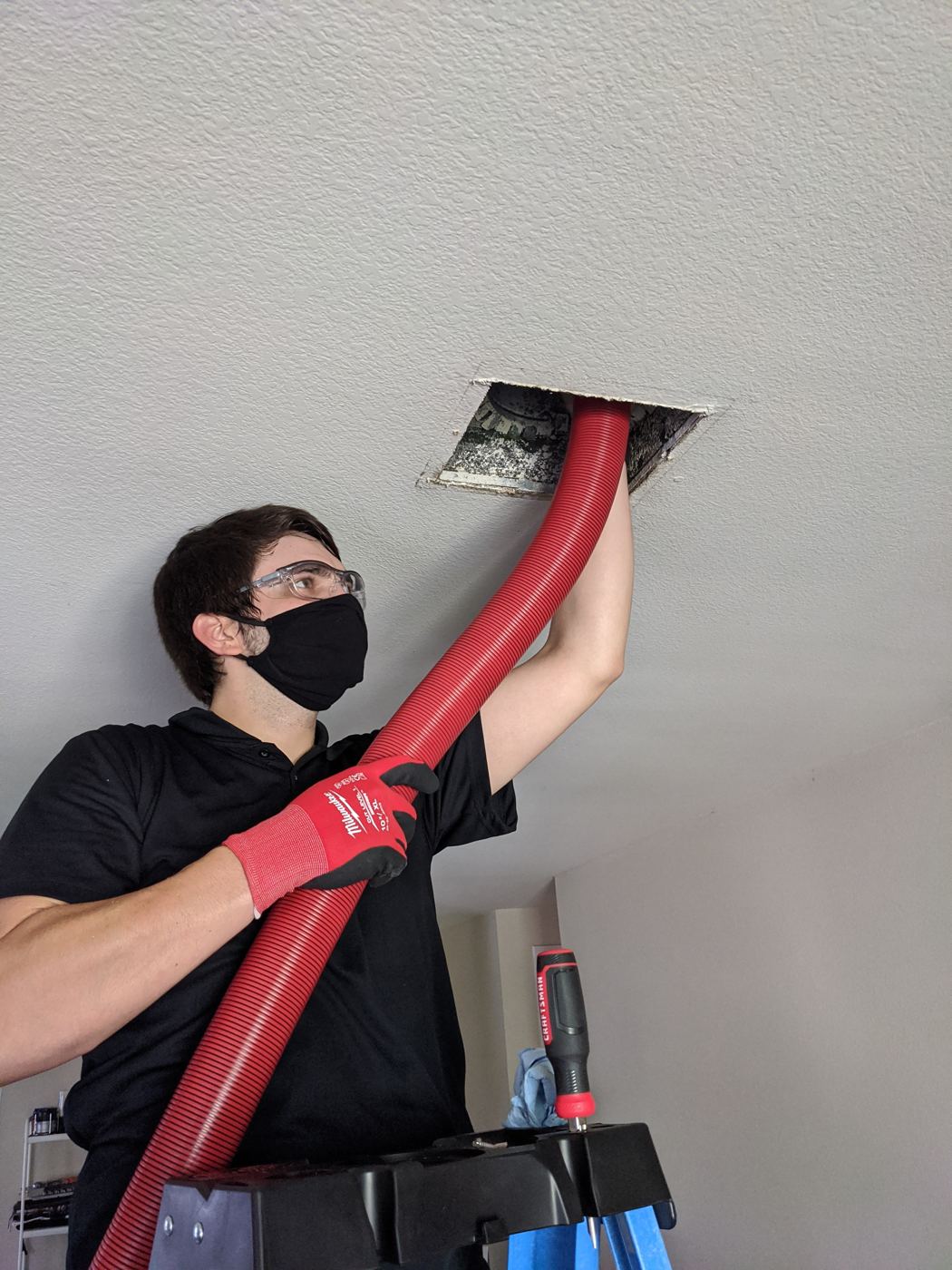 The BrushBeast vacuum line working a ceiling supply register.